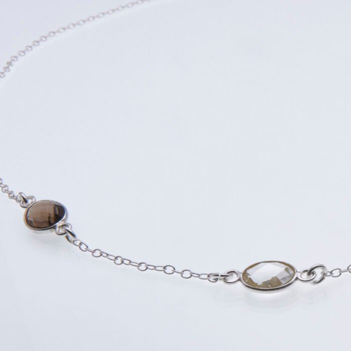 Smoky Quartz and Crystal Quartz 3-stone bezel-set Necklace on Sterling Silver Chain, image shows close up of Smoky Quartz and Crystal Quartz stones and part of chain, on white background