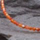 Carnelian and Sterling Silver Bracelet, image shows close-up of part of gemstone strand on dark background