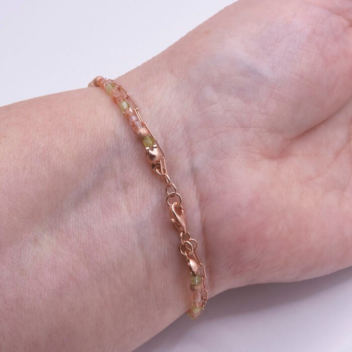Rose Gold Bee and Gemstone Bracelet, image shows clasp and part of bracelet strands, bracelet is being worn on wrist