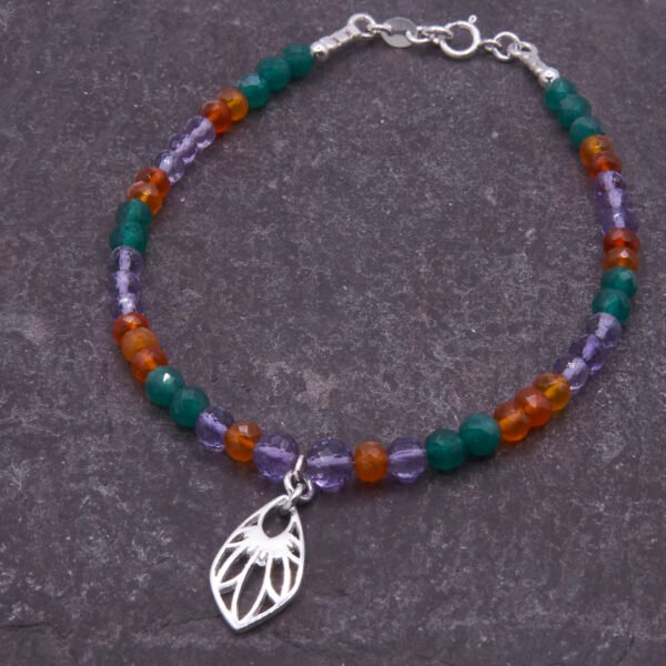 Mixed Gemstone Bracelet with Wildflower Charm, shown laid flat on dark grey slate