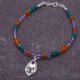 Mixed Gemstone Bracelet with Wildflower Charm, shown laid flat on dark grey slate