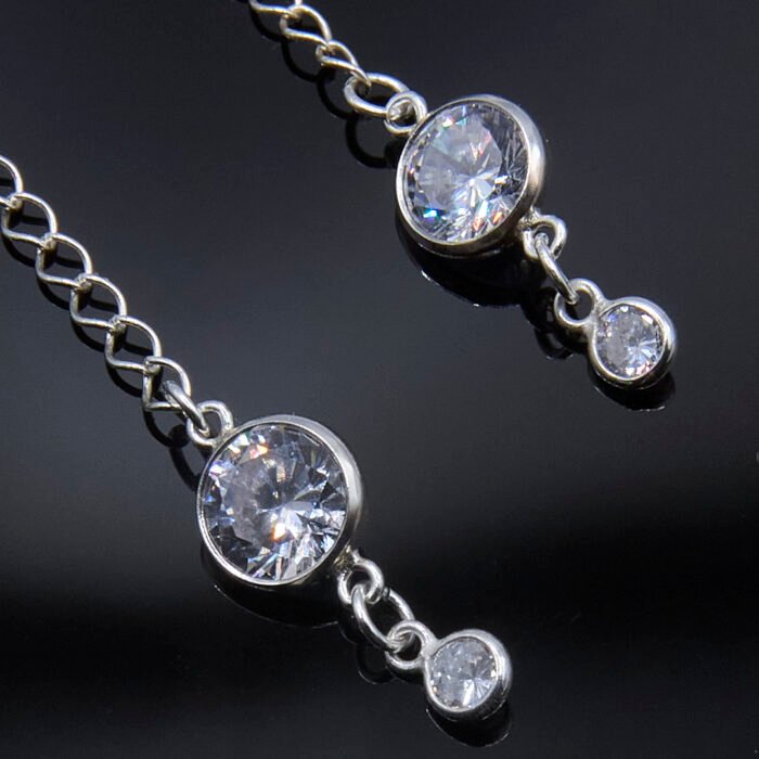 Sterling Silver Cubic Zirconia Dangle Earrings, image shows close-up of sparkly cubic zirconia stones on glossy black background