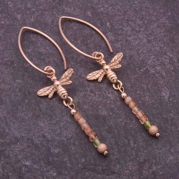 Rose Gold Bee and Gemstone Earrings, shown from above laid flat on dark slate background