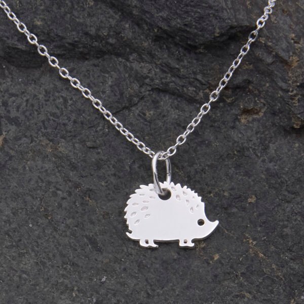 Hedgehog Charm Sterling Silver Necklace, shown close-up on dark stone background