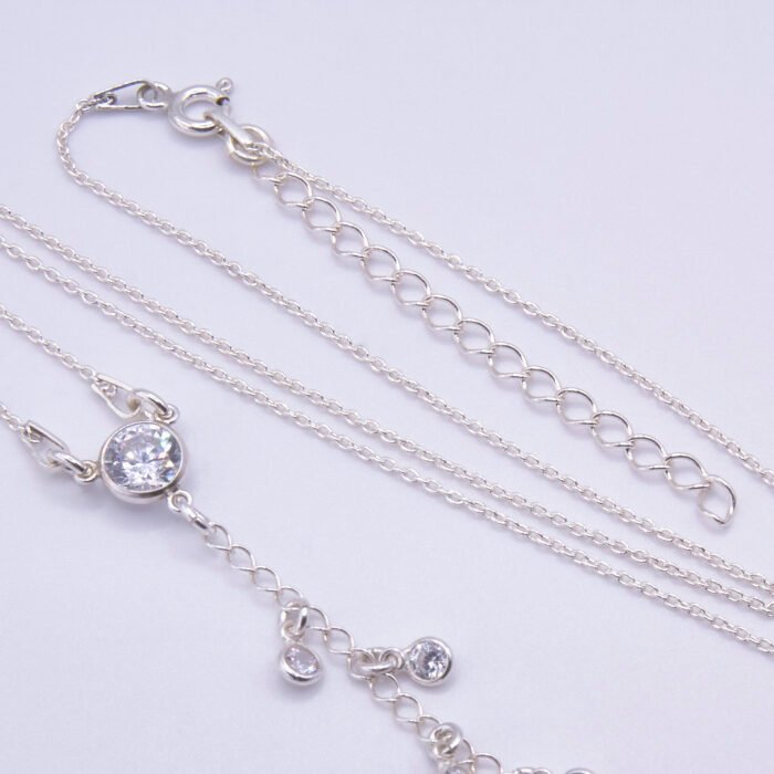 Sterling Silver and Cubic Zirconia Lariat Necklace, image shows close-up of cubic zirconia focal point and part of embellished chain, on plain white background