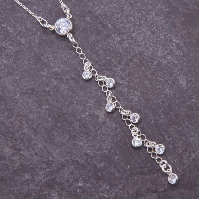 Sterling Silver and Cubic Zirconia Lariat Necklace, image shows close-up of cubic zirconia elements on dark slate background