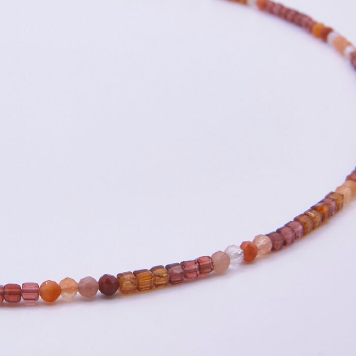 Garnet and Carnelian Gemstone Necklace, image shows close-up of part of gemstone strand, on plain white background