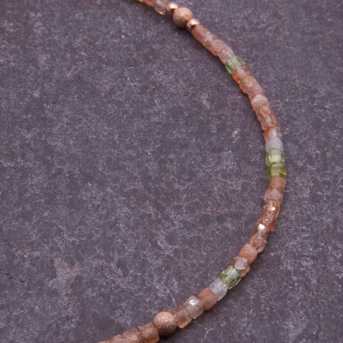 Rose Gold Bee and Gemstone Necklace, image shows close-up of part of gemstone strand on dark grey slate