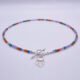 Mixed Gemstone Necklace with Wildflower Charm, shown on plain white background